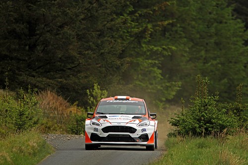 jason dickson's red and white rally car speeds towards the camera