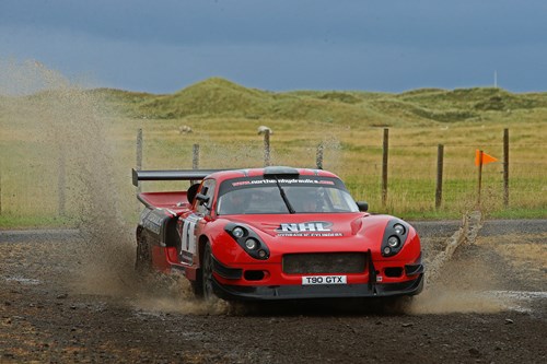 barry morris in red t90 gtr+ sports car skidding in the mud at the ni rally.